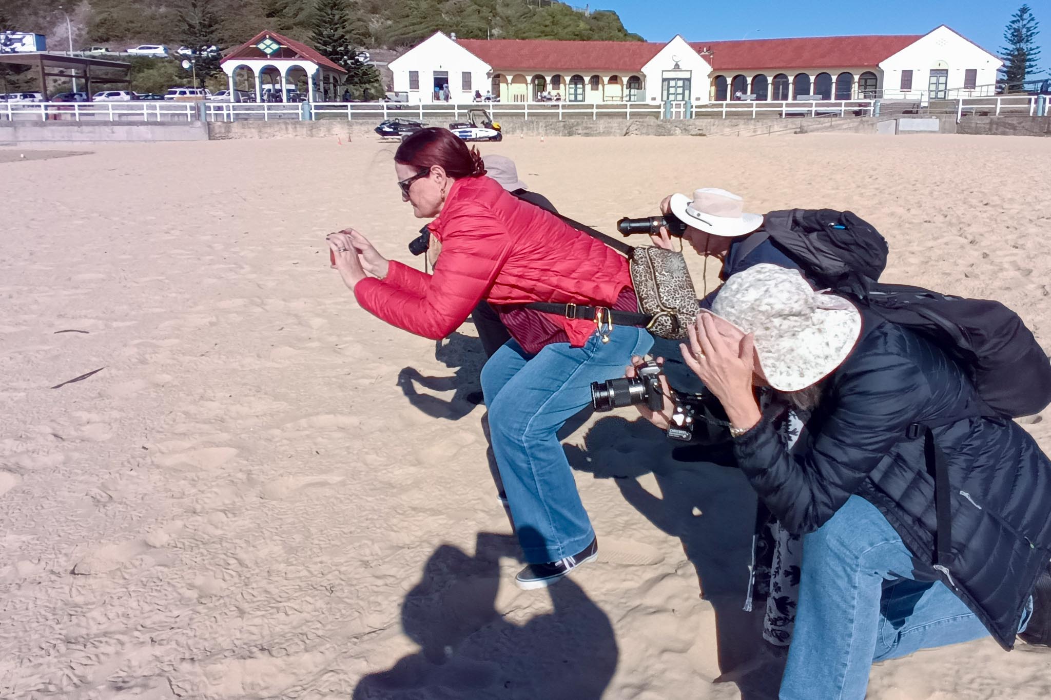 Photography workshop participants practising composition and observation techniques on a Newcastle beach.