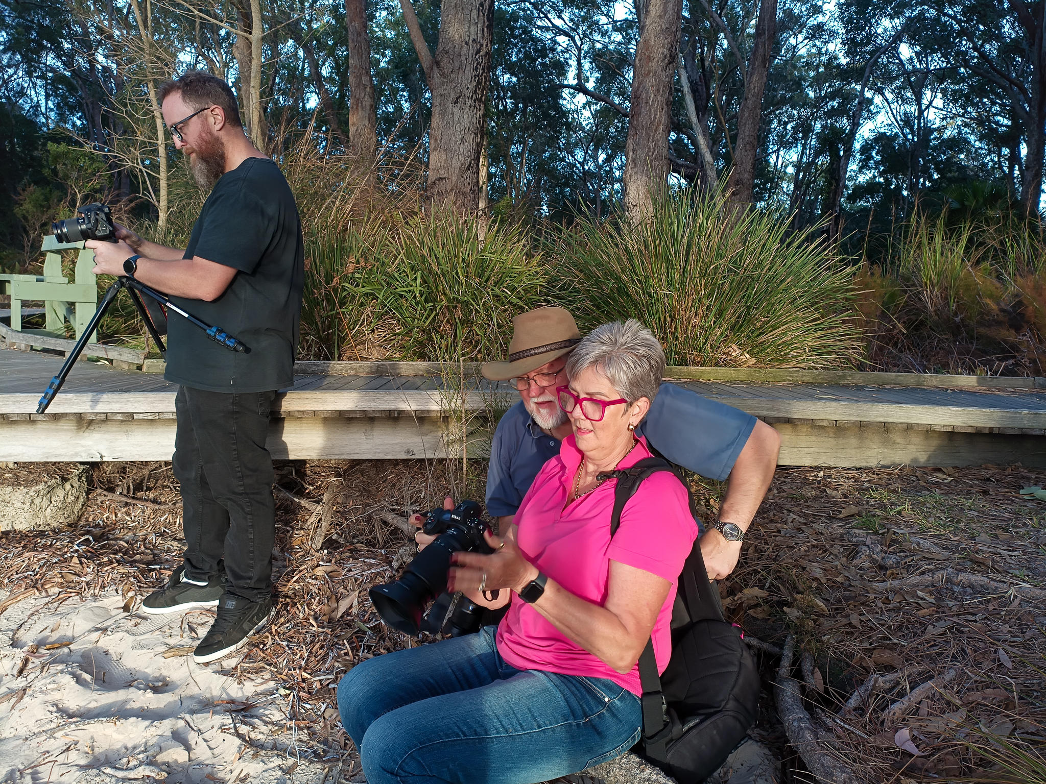 Photography workshop participants reviewing camera settings and composition during a field session