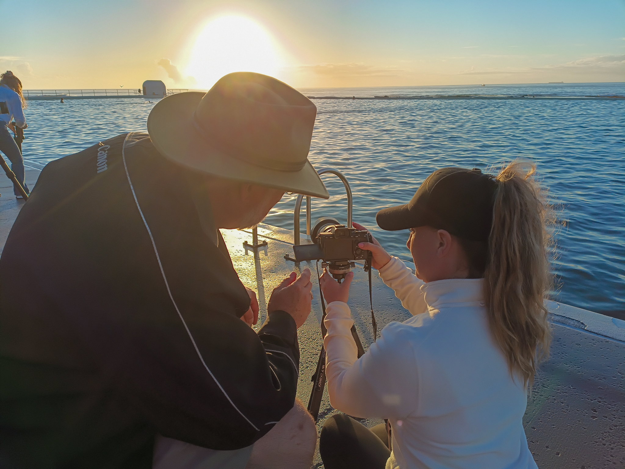 Photography workshops participant receiving camera guidance during a sunrise photography session at Newcastle Ocean Baths.